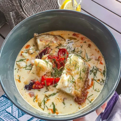 Kremet Norsk Fiskesuppe med fersk fisk og grønnsaker på en tallerken