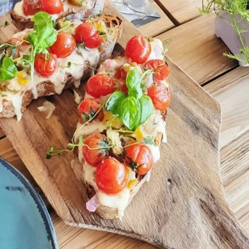 Bruschetta med cherrytomater og frisk basilikum på en tallerken.
