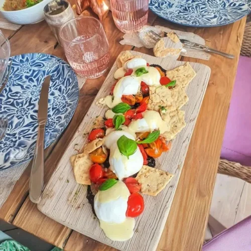 Burrata fett med friske tomater og kjeks på et serveringsfat