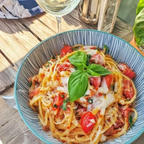 Pasta med tomatsaus toppet med fersk basilikum